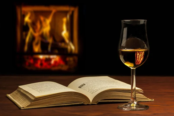 Open book with whisky and fire
