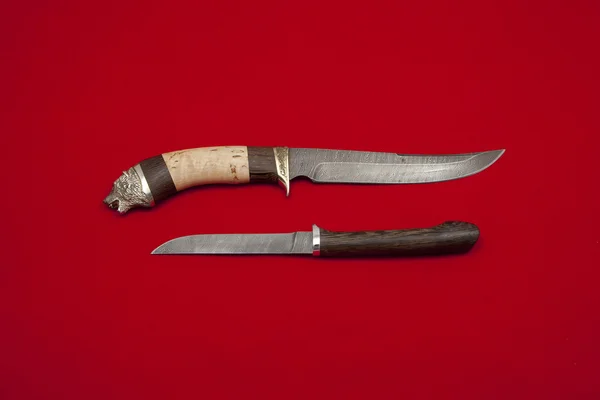 Two knives on red