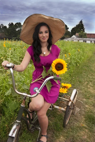 Woman on bike with sunflowers
