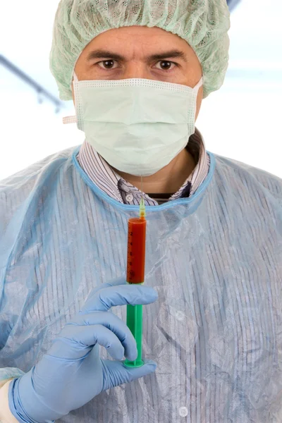 Young male doctor with mask holding syringe