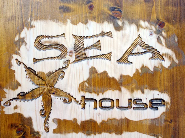 Wood carving with jellyfish and caption sea house