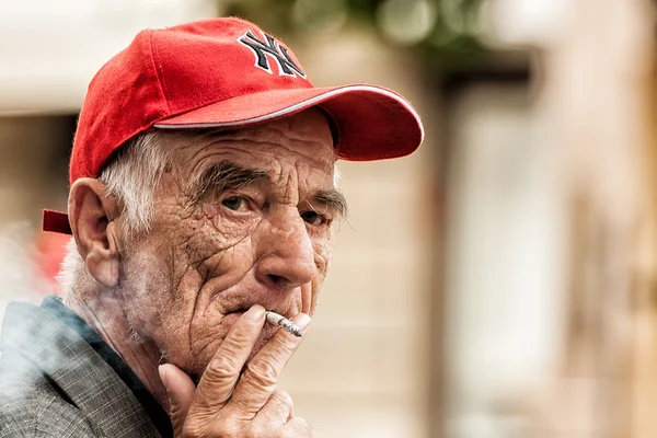 ZAGREB, CROATIA - MAY 24, 2009: Old man smoking a cigarette on t