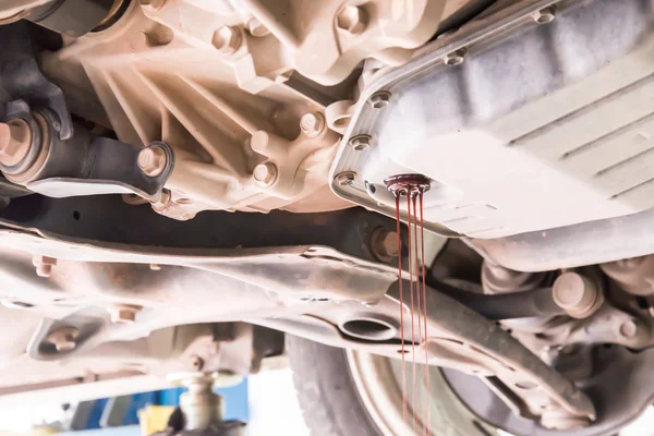 Mechanic changing engine oil.