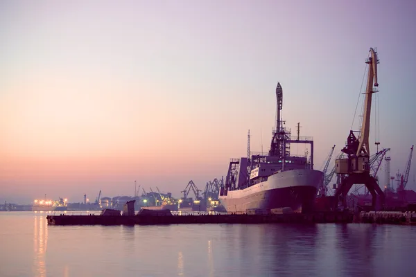 Cargo ship in the harbor at sunset