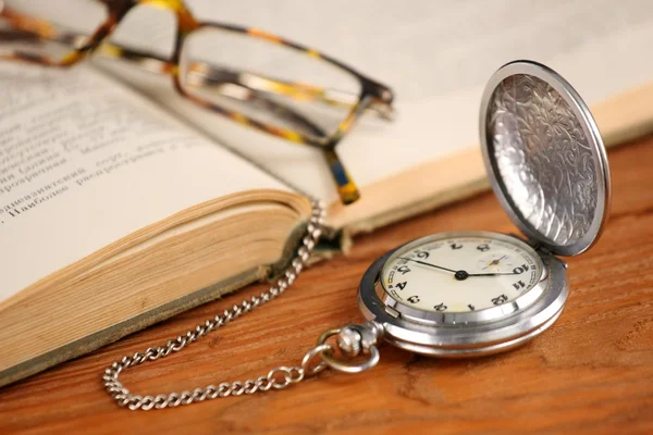 Vintage pocket watch glasses  and open old book
