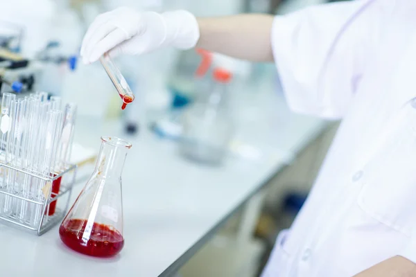 Decanting a violet liquid into a graduated cylinder