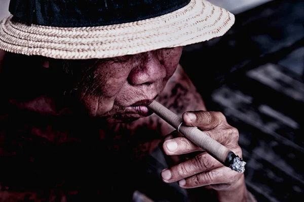 Very old Man smoke a cigarette