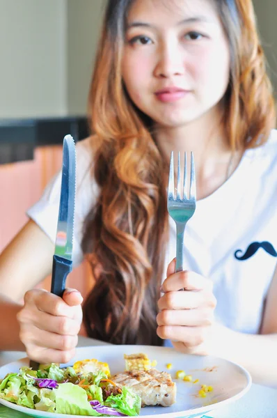 Woman holding a fork and a table knife