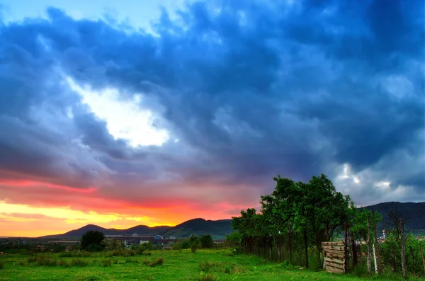 Colorful summer sunset just after a rainy day. Sun coloring the clouds.