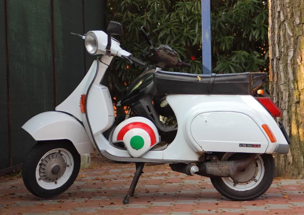 White motorcycle with helmet in italian colors