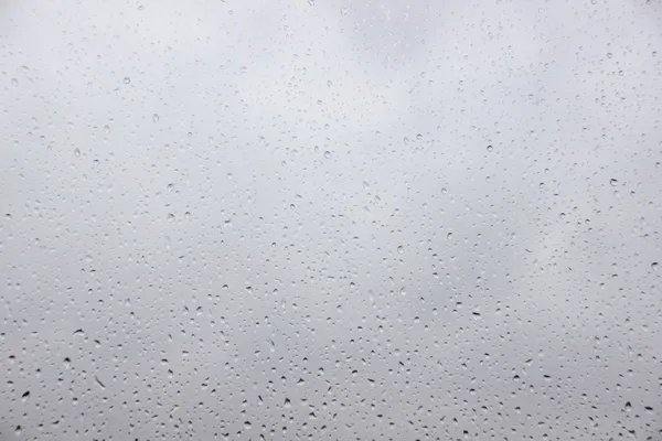 Raindrops on a window with heavy rain outside