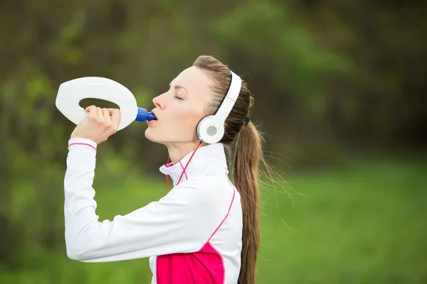 Running woman drinking water