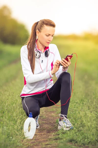 Beautiful fit girl using her mobile phone