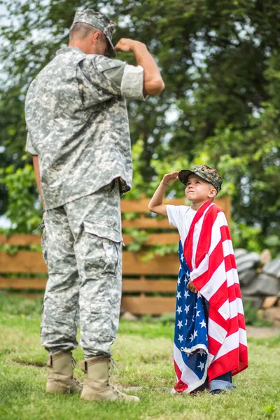 American soldier and his son salute each other