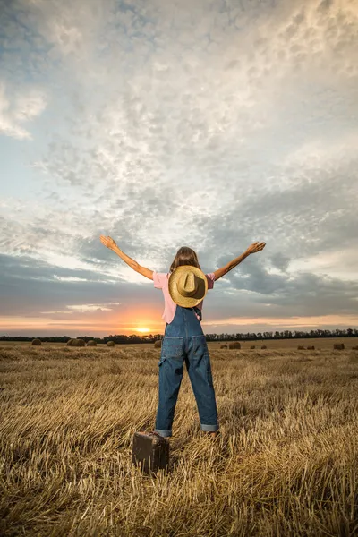 Young girl with hands up to the sky