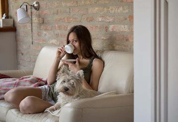 Girl drinks coffee and relax with dog