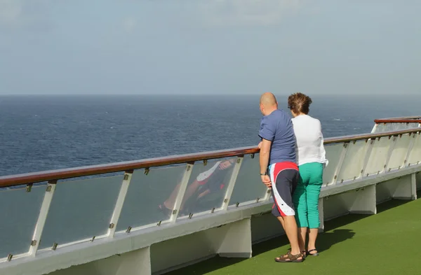 Man and woman looking in sea distance from board of cruise liner