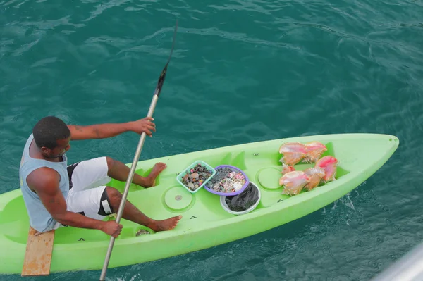 Dealer in souvenirs on  plastic kayak. Saint Lucia