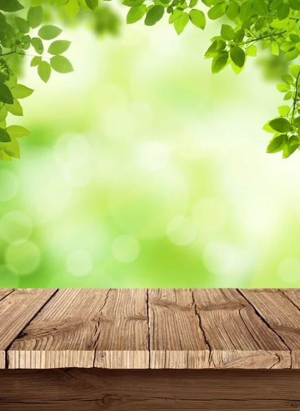 Fresh spring green bokeh background with wooden table for your products displays
