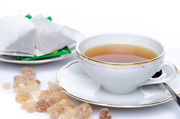 A cup of tea with sugar and tea bags