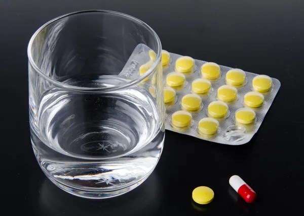 Glass of water with pills