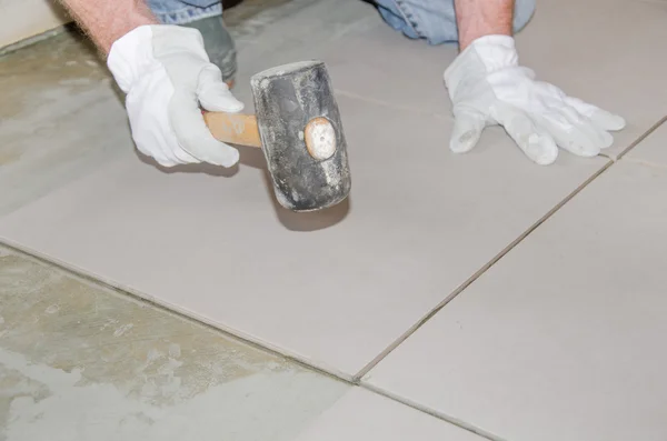 Tiler using a rubber mallet