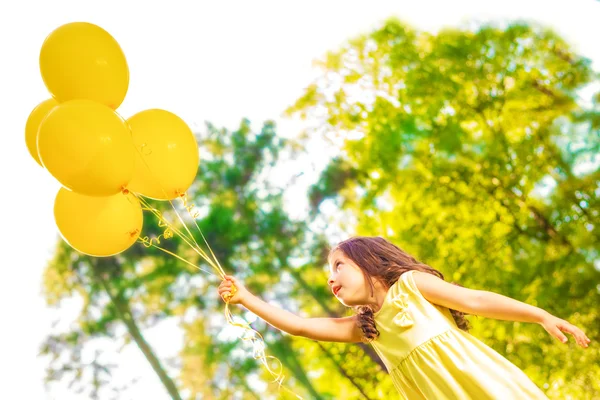 Happy girl with yellow balloons