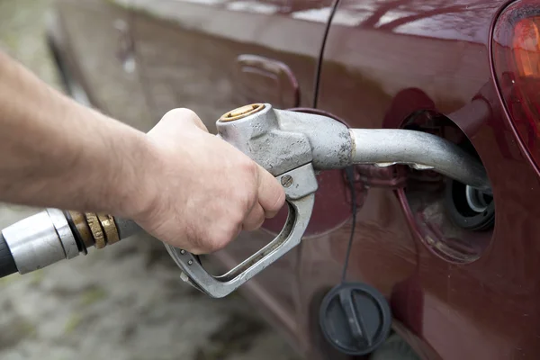 Close-up of a hand pumping gas in the car with a gas pump