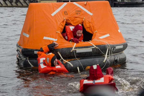 Seamen try to save their lives by boarding into the rescue craft.