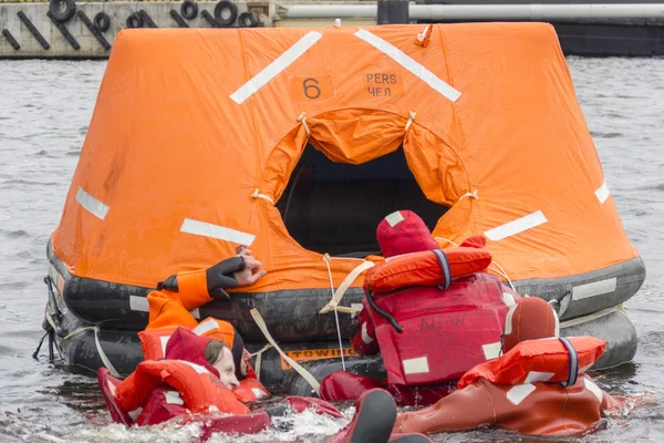 Seamen try to save their lives by boarding into the rescue craft.