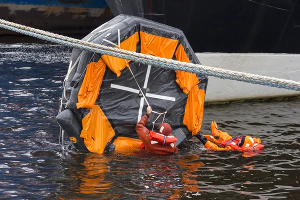 Man trying to invert the rescue craft.