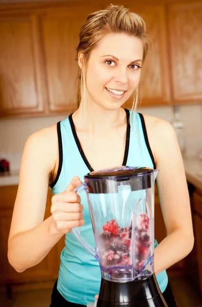 Woman making smoothie in blender