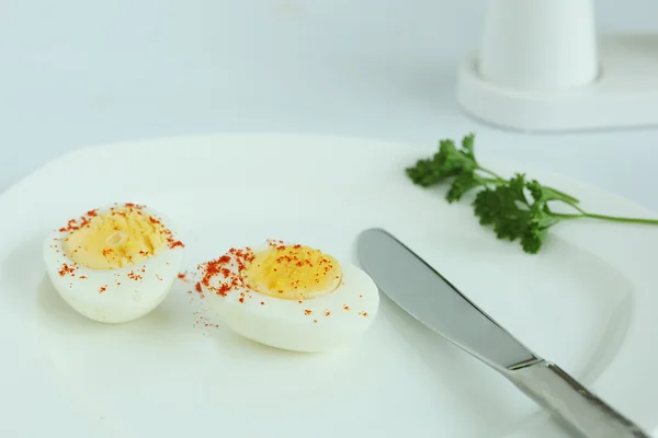 Hard boiled eggs sliced halves in white plate