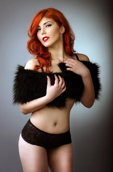 Curvy redhead woman posing in black lingerie