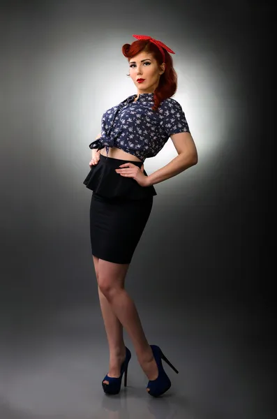 Full length portrait of a pin up girl posing with hands on waist