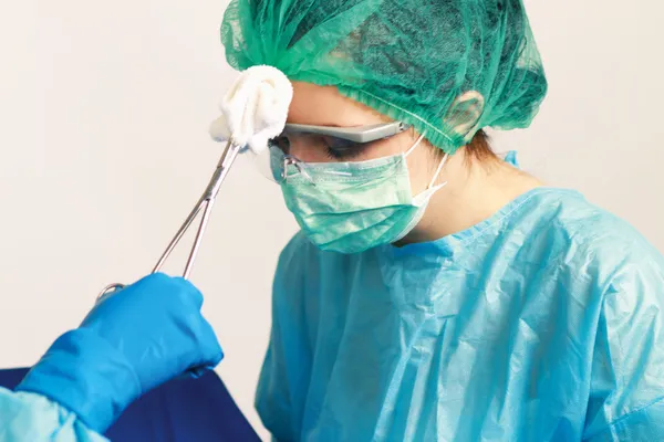 Surgeon holding medical instruments