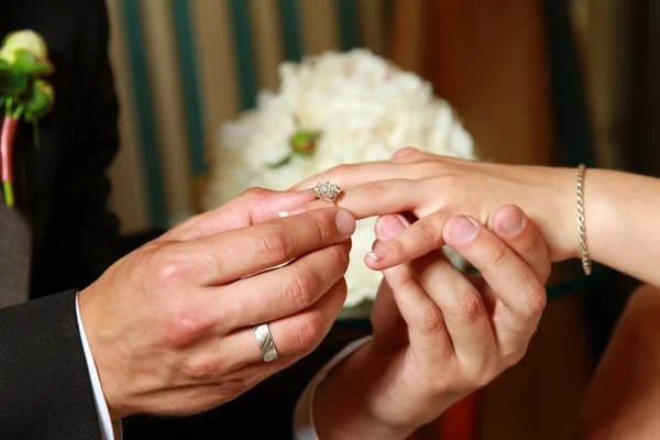 Man putting a ring on his woman\'s finger