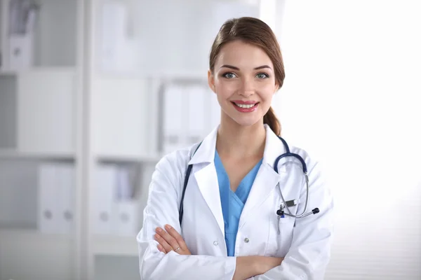 Portrait of young woman doctor with white coat standing in hospital