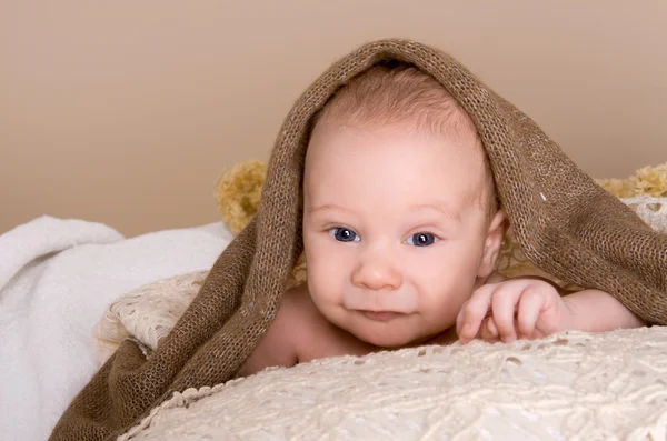 Newborn baby wrapped in  light brown soft fluffy cloth