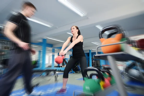 Action shot of woman exercising with kettle bell