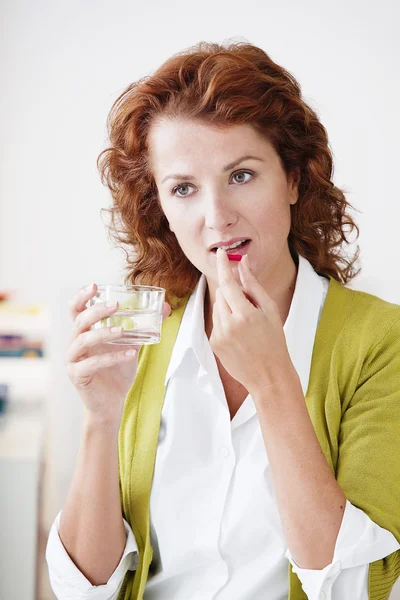 WOMAN TAKING MEDICATION