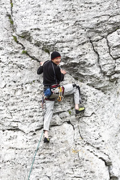 Man climbing natural rocky wall.