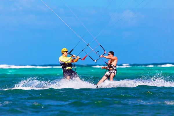 Two kitesurfers going towards each other on sea background Extre
