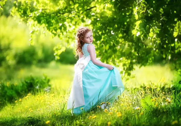 Beautiful little girl in a blue dress with a large white bow in