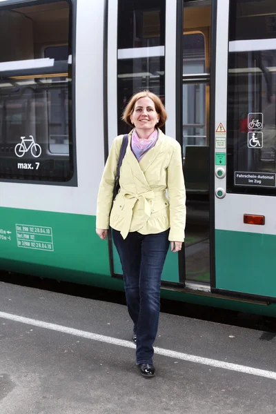 Smiling woman leaves the train