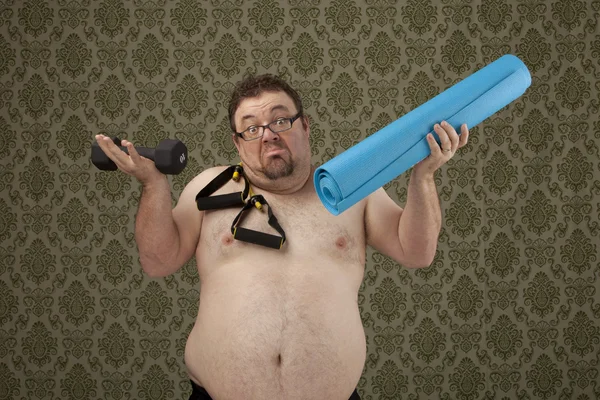 Shirtless, overweight male holding yoga mat and bands while wond