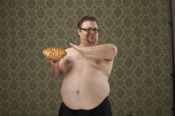 Overweight shirtless male holding a pie and saying no