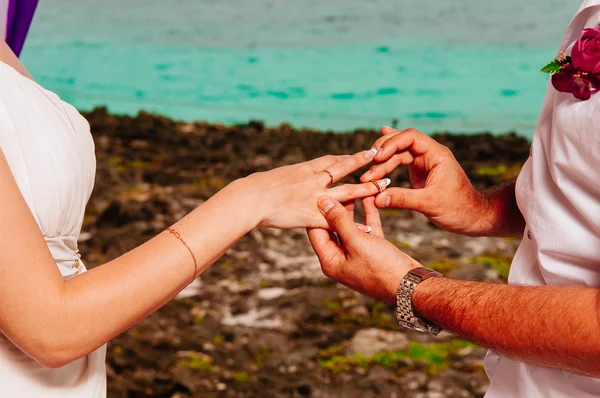 Groom put a ring on finger of his wife