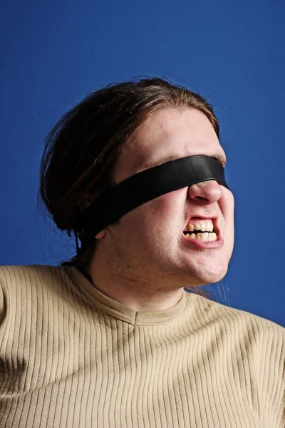 Man with a belt over his eyes