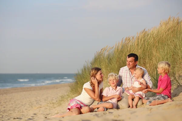 Happy family sitting together in dunes